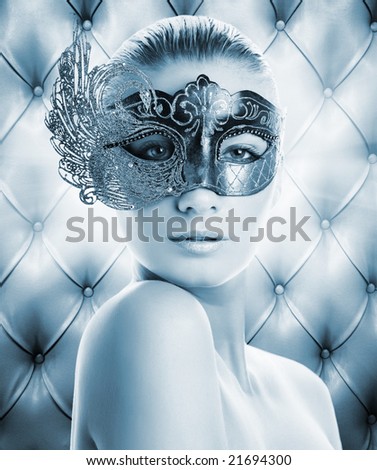Beautiful woman in carnival mask over abstract background (toned in blue)