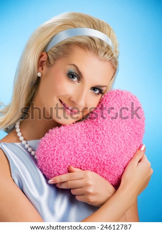 Beautiful young woman with fluffy heart pillow