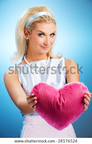 Beautiful young woman with fluffy heart pillow