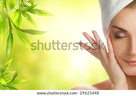Beautiful young woman applying organic cosmetics to her skin