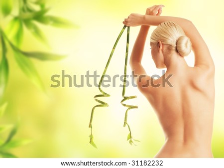 Beautiful young woman with green bamboo leaves