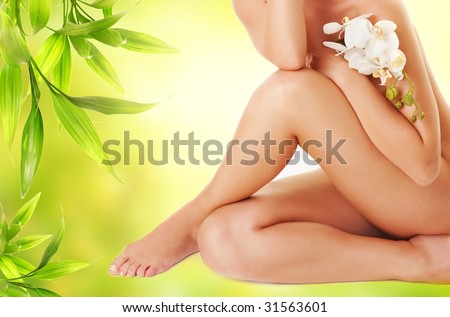 Female legs with white orchid