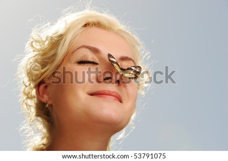 Beautiful butterfly sitting on a woman nose