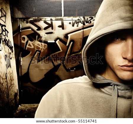 Cool looking hooligan in a graffiti painted gateway
