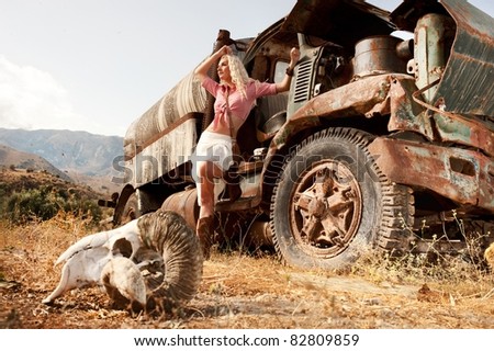 Attractive blond woman near an old truck.