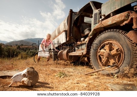 Attractive blond woman reffiling an old truck.