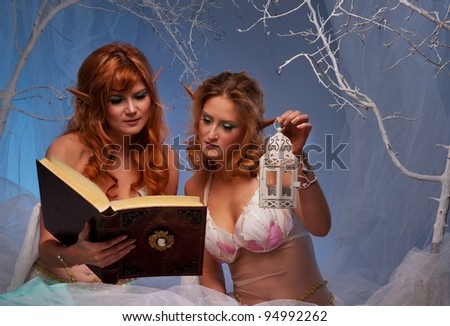Elves in magical  forest with a book.