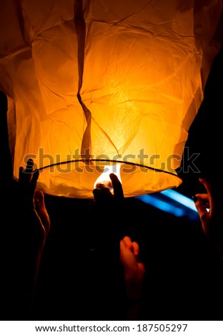 Make A Wish.Yellow lantern in human hands on dark background