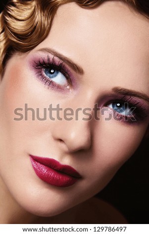Close-up portrait of young beautiful woman with stylish make-up and retro hairdo