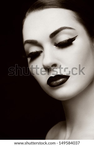 Duotone portrait of young beautiful woman with eyeliner and false lashes