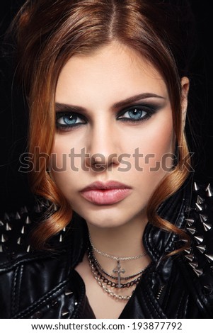 Portrait of young beautiful woman in spiked leather jacket