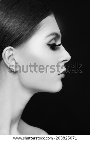Black and white profile portrait of young beautiful woman with extended eyelashes
