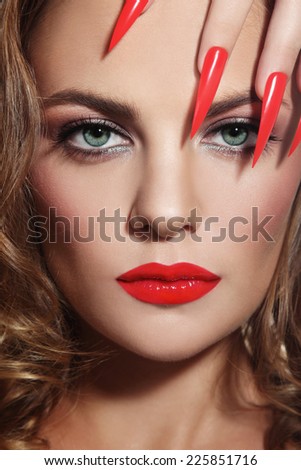 Close-up portrait of young beautiful woman with red lipstick and long stiletto nails
