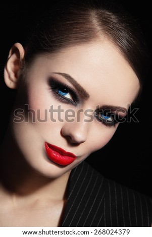 Portrait of young beautiful woman with smoky eyes and red lipstick