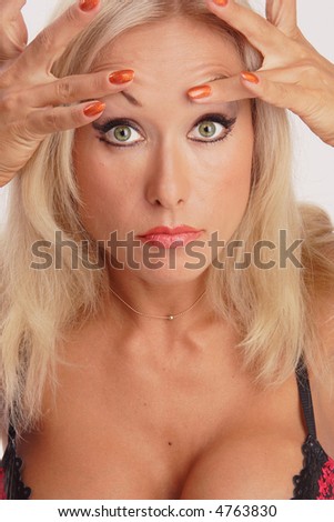 stock photo Heavy maked up tanned girl exploring her face to go the