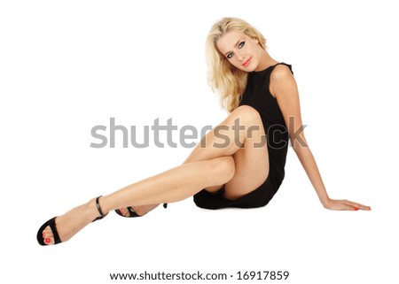 stock photo Beautiful slim blonde girl in cocktail dress sitting on white 