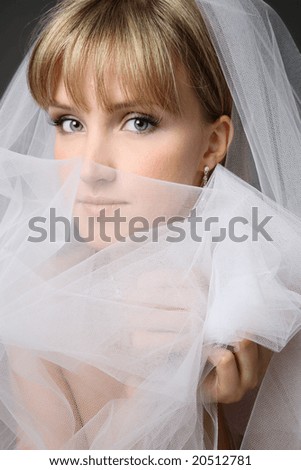 Close-up portrait of young beautiful thoughtful bride in bridal veil
