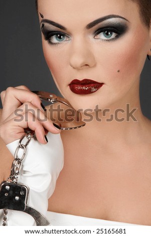 Girl in white vinyl dress and gloves holding cuffs