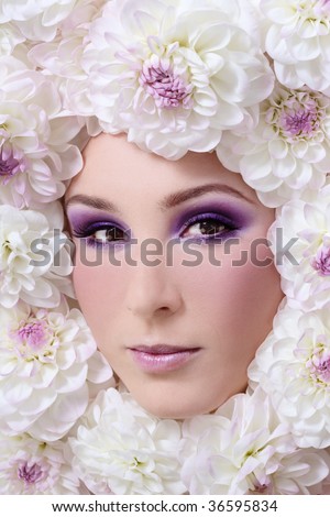 Portrait of beautiful girl with stylish makeup and white flowers around her face