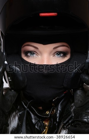 Portrait of beautiful woman with stylish makeup in black biker helmet, mask and gloves