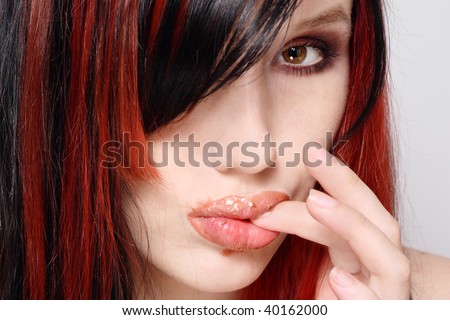 Closeup portrait of young sexy girl eating creamy cake and licking