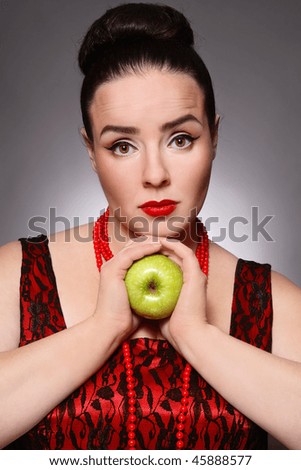 Attractive plus-size woman of middle age with green apple in hands
