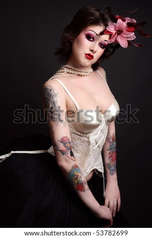 Beautiful slim young tattooed woman in ballet skirt and vintage corset