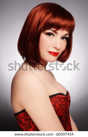 stock photo Beautiful redhead woman with green eyes in sexy red corset