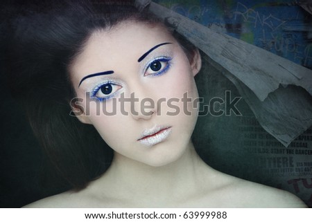 Portrait of young beautiful woman with sparkly futuristic make-up on grainy damaged vintage background