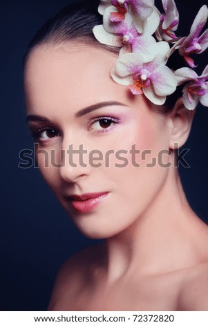 Young beautiful woman with orchid in her hair