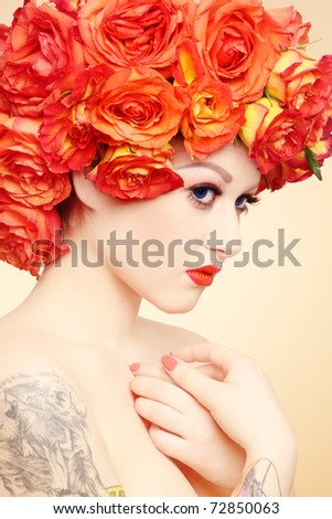 Beautiful sexy girl with tattoos and fancy wig of bright orange roses