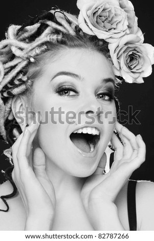 Black and white shot of beautiful young sexy girl with fancy hairstyle and roses crying