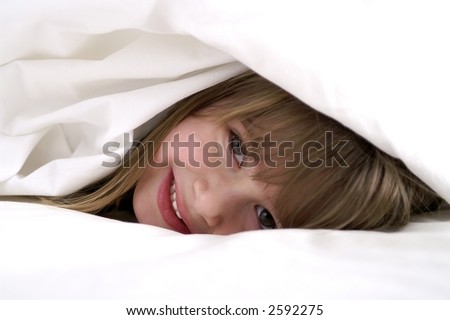 A young girl playing in the sheets