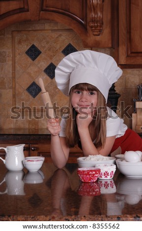 A cute young girl getting ready to bake cupcakes for valentines day