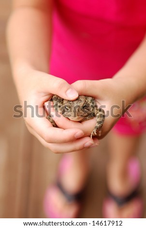 A young girl holding a toad