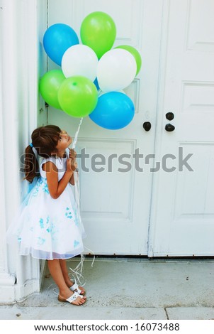 A cute girl holding a bunch of balloons