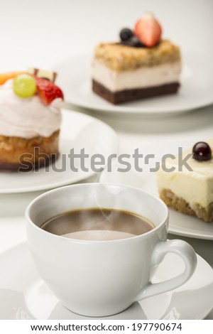 Hot freshly brewed cup of aromatic coffee served with a variety of cakes or pastries in a restaurant, for a coffee break or when entertaining at a party