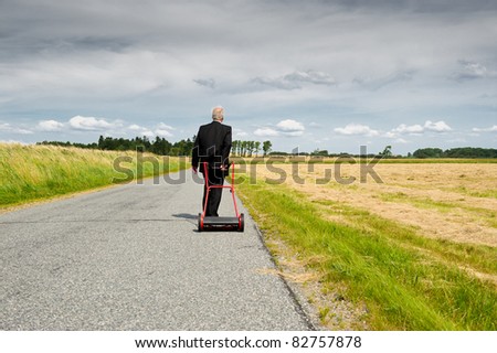 Businessman in Wheat Field. Man in a dark business suit cutting down wheat in a farm field. Metaphor for harvesting the fruits of your labor