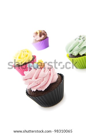 Scattered colorful cupcakes. Over a white background