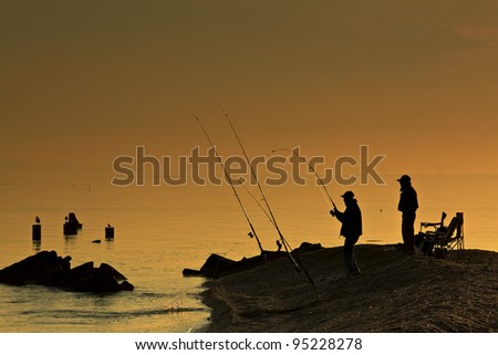 silhouette of men fishing on the bay early morning