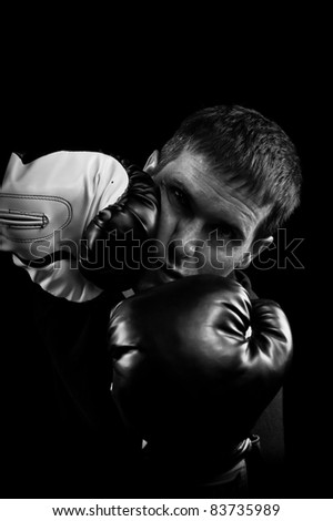 A Low key black and white image of a man in a boxing match being hit in the face