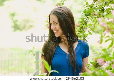 Happy young white woman with black hair smiling sunny summer portrait