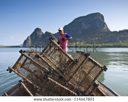 PANYI, THAILAND-FEBRUARY 7: A fisherman uses the net trap for capturing the wild sea fish  on February 7, 2009 in Panyi, Thailand. Panyi island is the unique floating community in south Thailand.