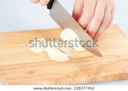cutting onions on a wooden cutting board