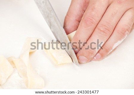 Preparation and cutting dough for pasta cooking on a white background