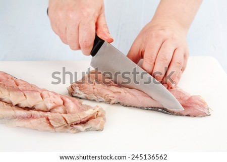 the process of cutting the cod fillets on a cutting board