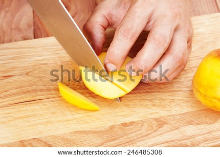 Chef-cook sliced peach on a cutting board. Cutting ingredients closeup
