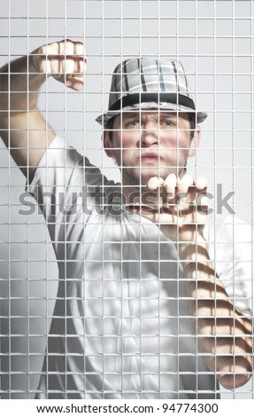 angry guy in the hat behind bars