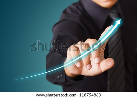 Businessman touching a rising arrow, representing business growth.