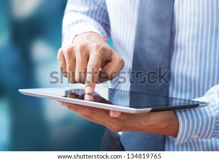 Business hand presses on screen digital tablet